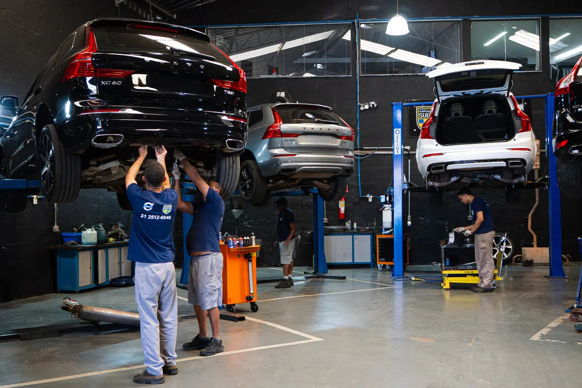 Equipe da Garagem Sueca trabalhando sob um Volvo XC60 no elevador